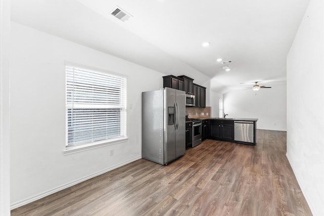 kitchen featuring stainless steel appliances, dark hardwood / wood-style flooring, sink, tasteful backsplash, and ceiling fan