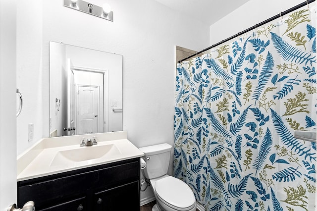 bathroom featuring a shower with shower curtain, vanity, and toilet