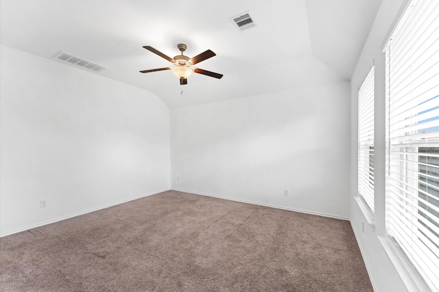 carpeted spare room with vaulted ceiling and ceiling fan