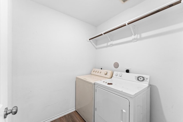 clothes washing area featuring dark hardwood / wood-style flooring and washer and dryer