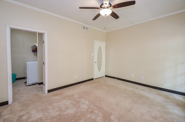 unfurnished bedroom featuring washer / clothes dryer, crown molding, and light colored carpet