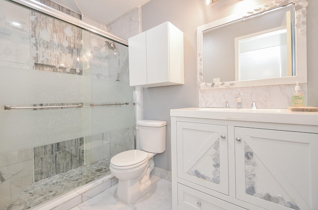 bathroom featuring vanity, backsplash, a shower with door, and toilet