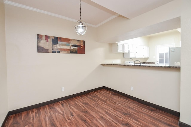 kitchen featuring decorative light fixtures, white cabinetry, stainless steel fridge, dark stone counters, and crown molding