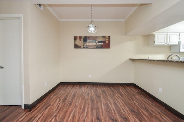 unfurnished dining area featuring ornamental molding and dark hardwood / wood-style flooring