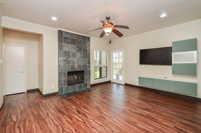 unfurnished living room with crown molding, ceiling fan, wood-type flooring, and a tiled fireplace