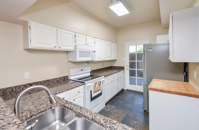 kitchen featuring butcher block counters, sink, white cabinets, and white appliances