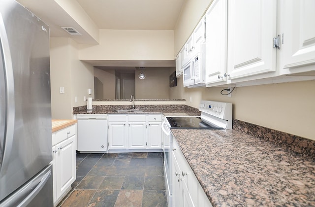 kitchen with sink, white appliances, dark stone counters, and white cabinets