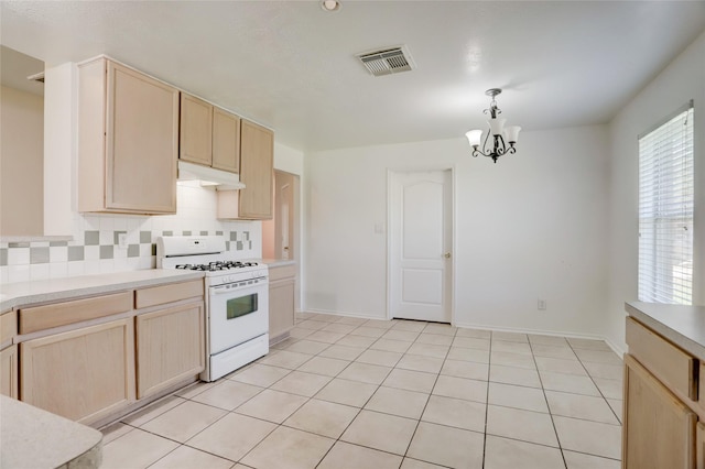 kitchen featuring white range with gas stovetop, under cabinet range hood, and light brown cabinetry