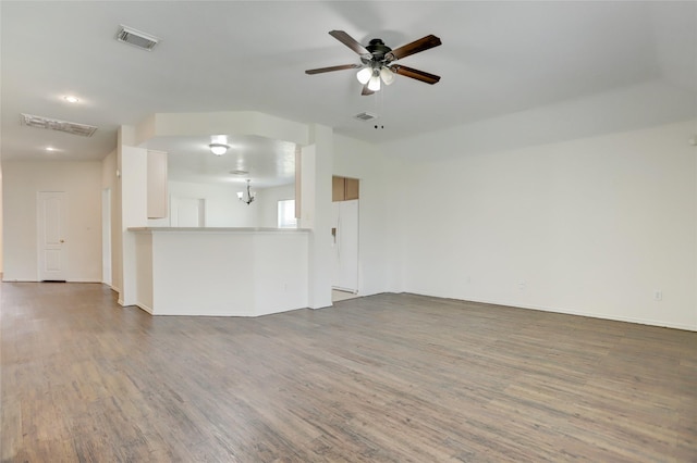 unfurnished living room featuring visible vents, ceiling fan with notable chandelier, and wood finished floors