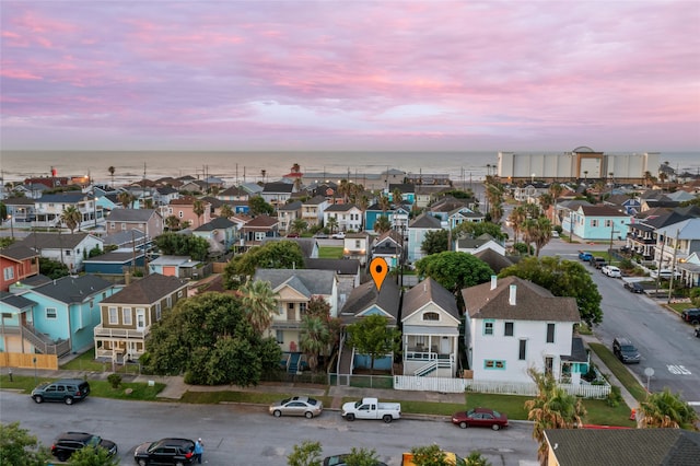 aerial view at dusk with a residential view and a water view