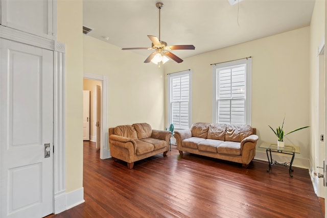 living room with dark wood-type flooring, visible vents, baseboards, and a ceiling fan