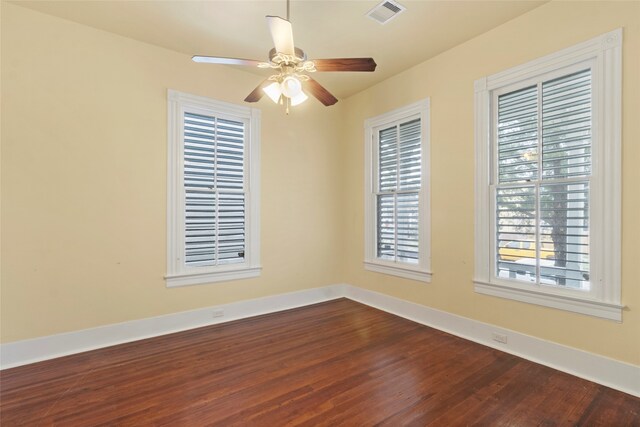 1621 Ursuline St, Galveston, TX 77550 - spare room with baseboards, visible vents, dark wood-type flooring, and a ceiling fan