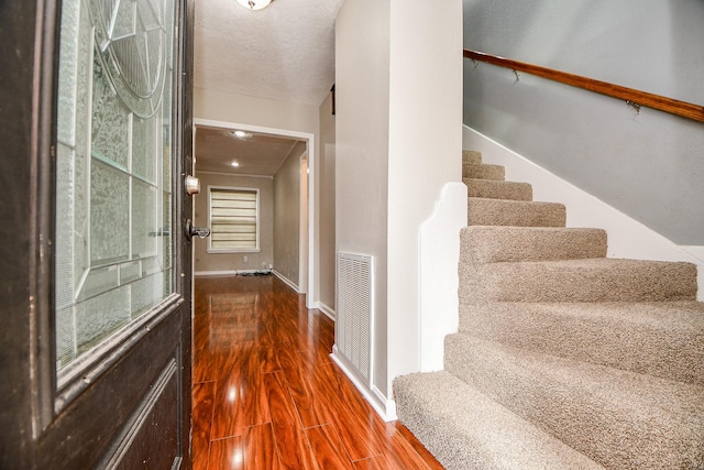 entryway with hardwood / wood-style flooring and a textured ceiling