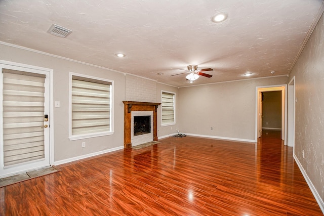 unfurnished living room with crown molding, ceiling fan, a fireplace, and hardwood / wood-style flooring