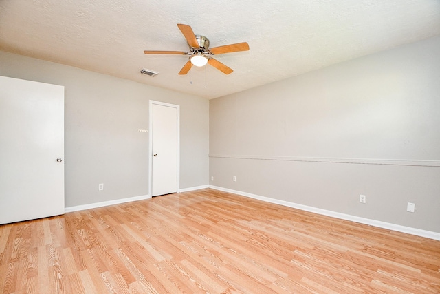 unfurnished room with ceiling fan, a textured ceiling, and light wood-type flooring