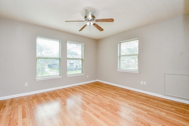 empty room with plenty of natural light, ceiling fan, and light hardwood / wood-style flooring