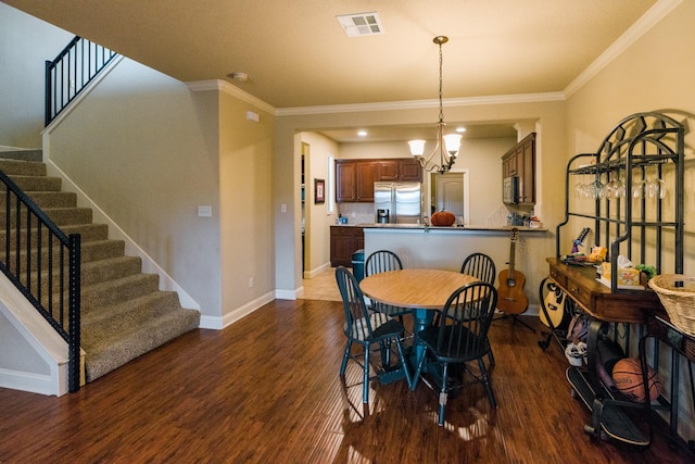 dining room with ornamental molding, dark wood-type flooring, and a notable chandelier