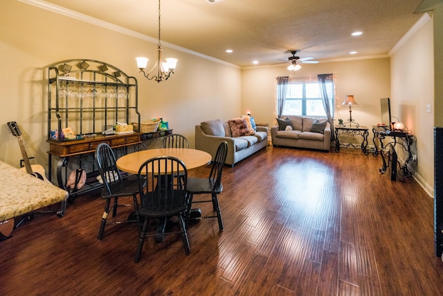 dining room with ceiling fan with notable chandelier, dark wood-type flooring, and ornamental molding