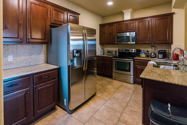 kitchen with stainless steel appliances, sink, decorative backsplash, and light tile patterned floors