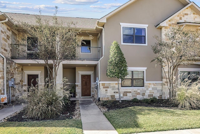 multi unit property featuring a front yard and a balcony