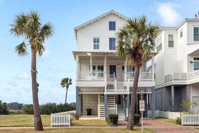 beach home featuring covered porch and a front lawn