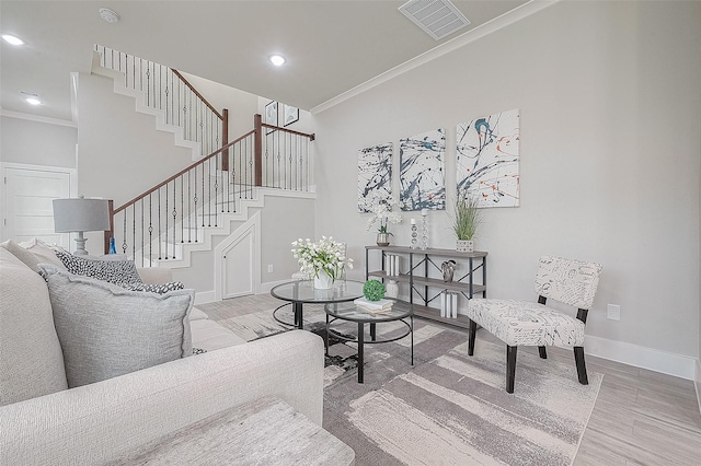 living room with crown molding and light hardwood / wood-style floors