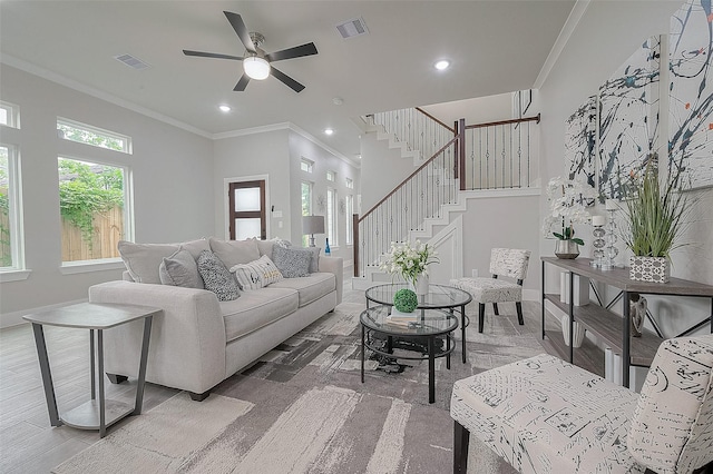 living room featuring ceiling fan, ornamental molding, and light hardwood / wood-style floors