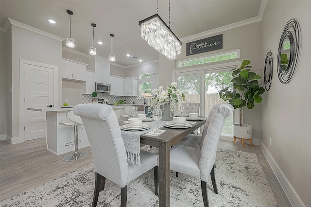 dining area featuring crown molding, sink, and light hardwood / wood-style flooring