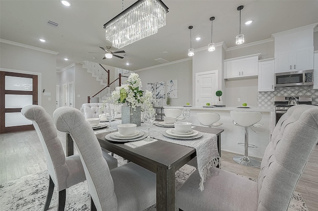 dining area with crown molding, ceiling fan, and light wood-type flooring