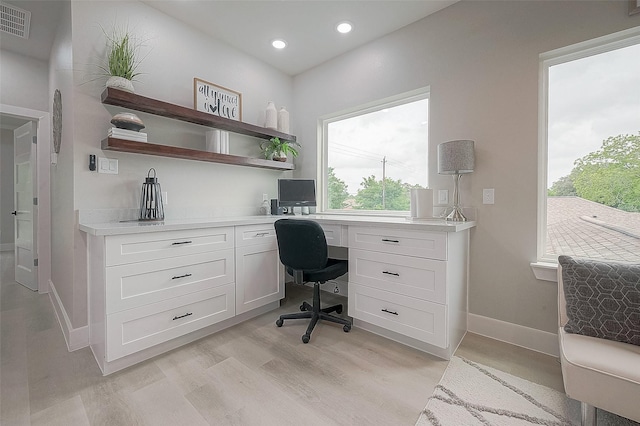 home office featuring built in desk and light hardwood / wood-style flooring