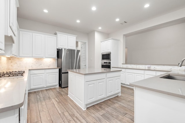 kitchen featuring light countertops, appliances with stainless steel finishes, wood finish floors, and a sink