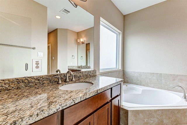 bathroom featuring vanity and tiled bath