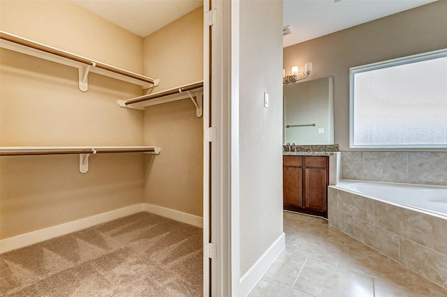 spacious closet with sink and light tile patterned flooring