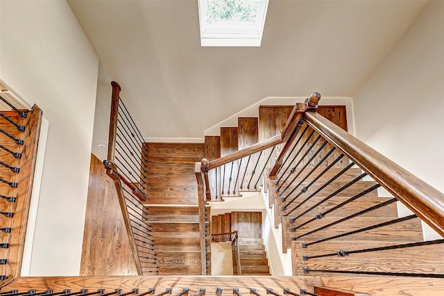 staircase featuring wood-type flooring and a skylight