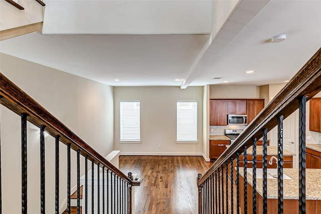 staircase featuring recessed lighting, baseboards, and wood finished floors