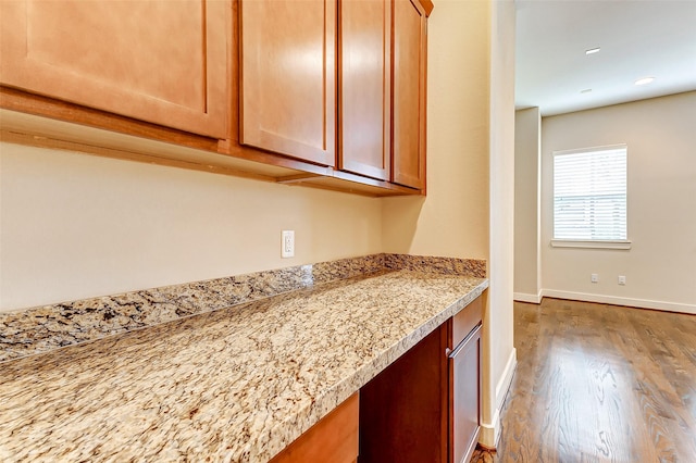 kitchen with hardwood / wood-style flooring and light stone countertops