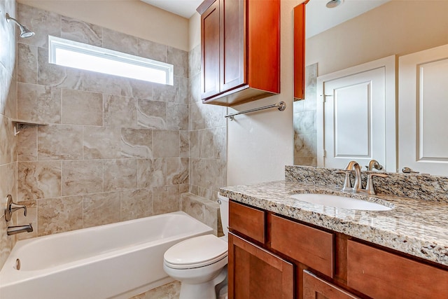 full bathroom featuring tiled shower / bath, vanity, and toilet