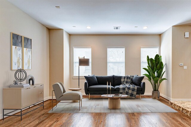 living room with baseboards, recessed lighting, wood finished floors, and visible vents