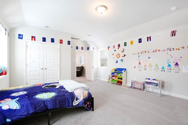 bedroom with a closet, vaulted ceiling, and light carpet