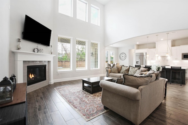 living room featuring a tile fireplace and dark hardwood / wood-style floors