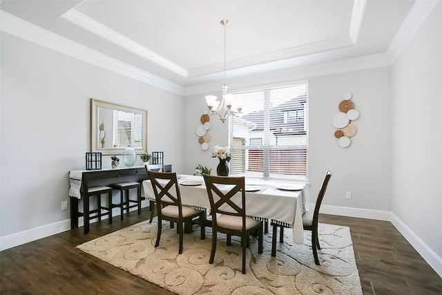 dining space with ornamental molding, an inviting chandelier, dark hardwood / wood-style flooring, and a tray ceiling