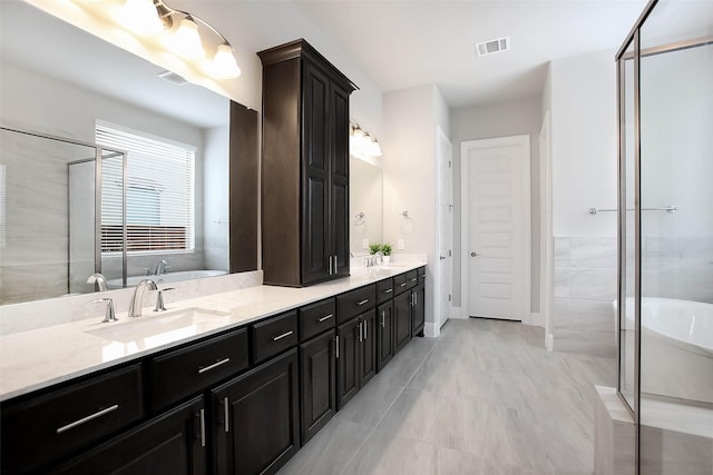 bathroom with vanity and shower with separate bathtub