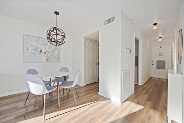 dining room featuring hardwood / wood-style floors and a chandelier