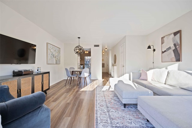 living room with a chandelier and light hardwood / wood-style flooring