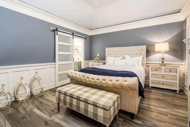 bedroom featuring crown molding, dark hardwood / wood-style floors, and a barn door