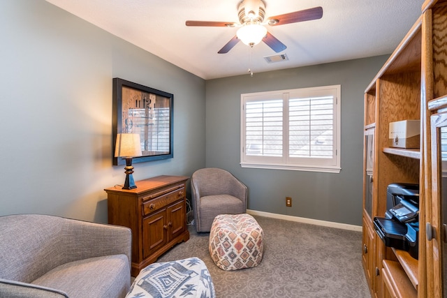 sitting room featuring light colored carpet and ceiling fan