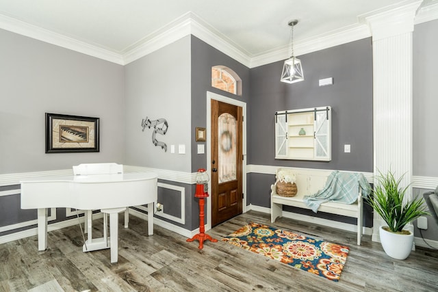 entrance foyer featuring crown molding, wood-type flooring, and ornate columns