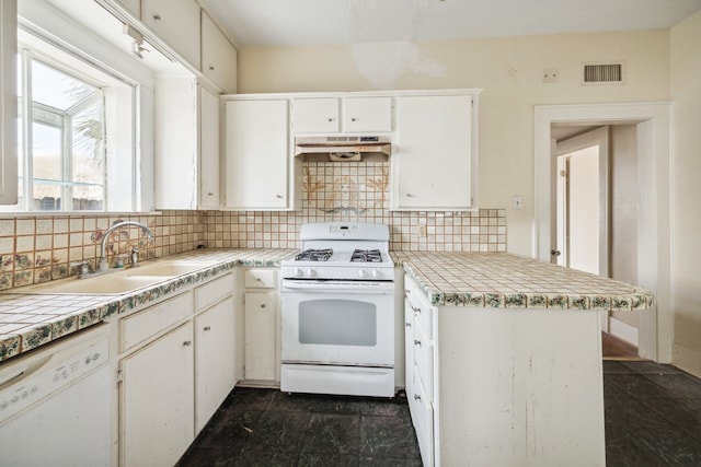 kitchen featuring white cabinetry, kitchen peninsula, sink, white appliances, and tasteful backsplash