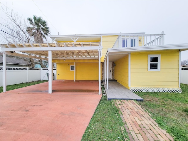 rear view of property with a lawn and a carport