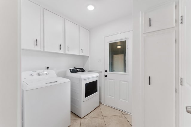 clothes washing area with cabinets, light tile patterned flooring, and independent washer and dryer